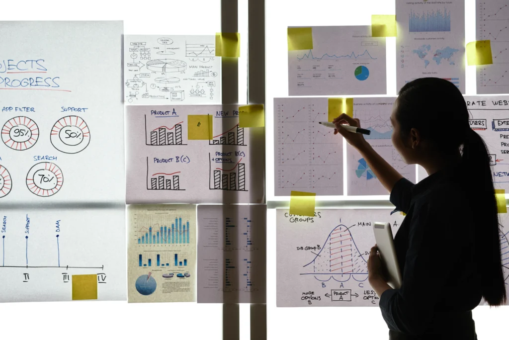 asian-woman-standing-window-office-looking-printouts-with-business-graphs-glass